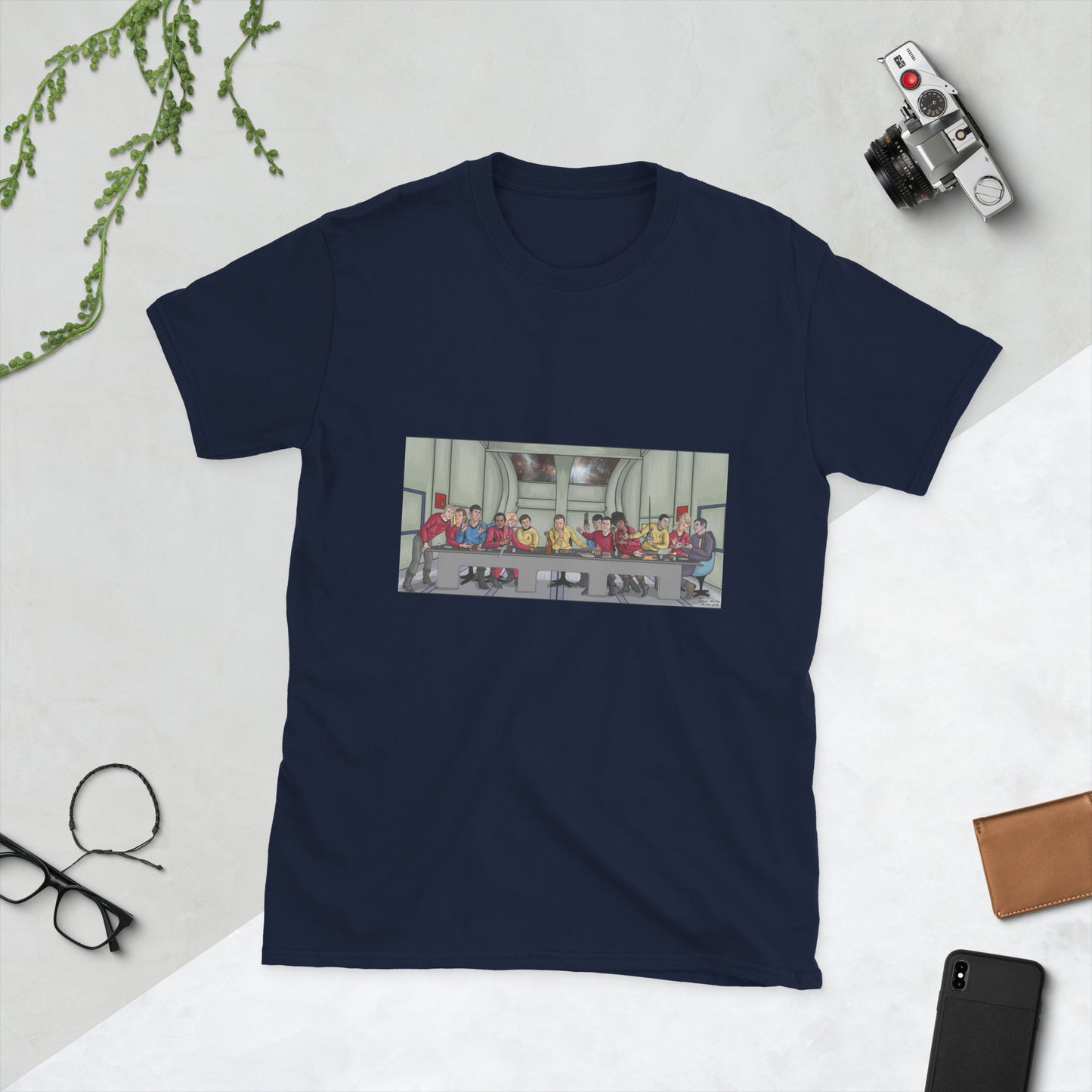 A dark blue t-shirt with a rectangle image in the front centre that depicts The Last Supper painting by Michelangelo but done in cartoon style with the crew and cast of Star Trek the Original series depicted as the apostles and Jesus