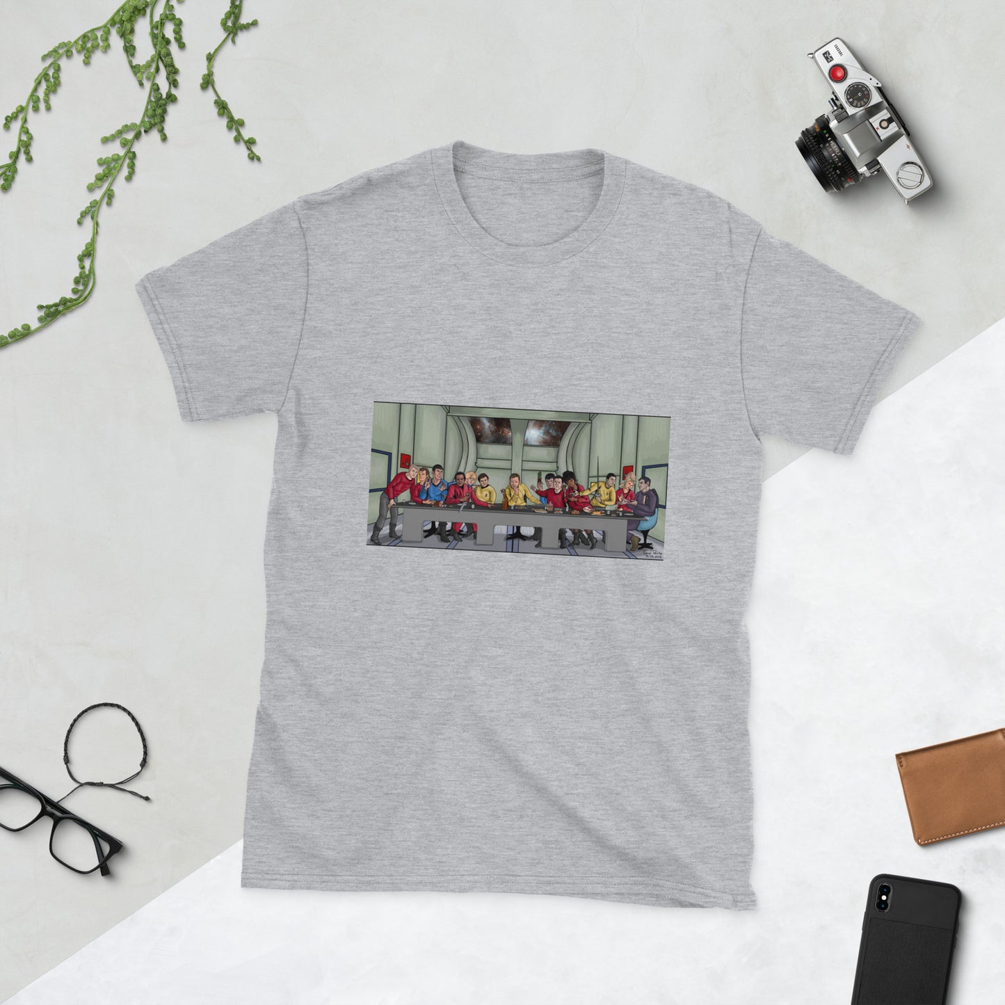 A light grey t-shirt with a rectangle image in the front centre that depicts The Last Supper painting by Michelangelo but done in cartoon style with the crew and cast of Star Trek the Original series depicted as the apostles and Jesus