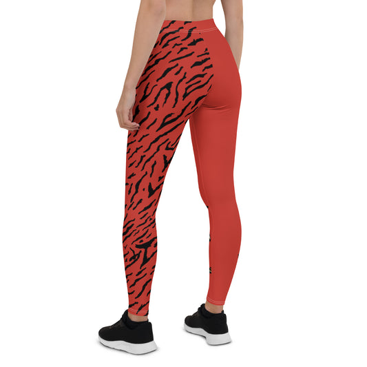 Female model wearing Red leggings with a hand drawn tiger on the right lower leg and black tiger print covers the left leg and waist fully on the left side, front and back.