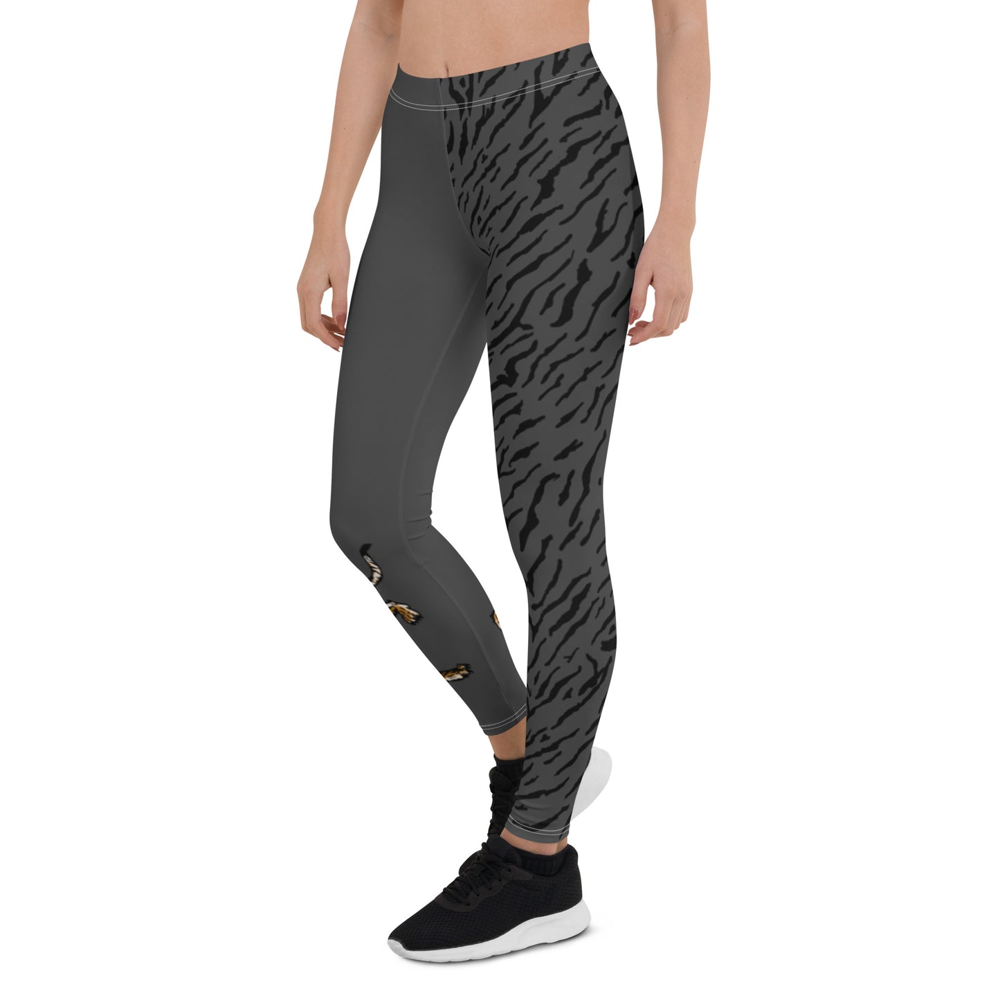 Female model wearing grey leggings with a hand drawn tiger on the right lower leg and black tiger print covers the left leg and waist fully on the left side, front and back.