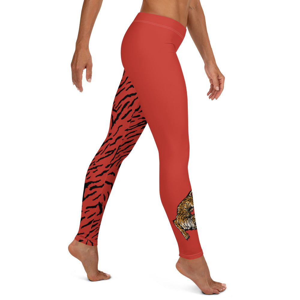 Female model wearing Red leggings with a hand drawn tiger on the right lower leg and black tiger print covers the left leg and waist fully on the left side, front and back.