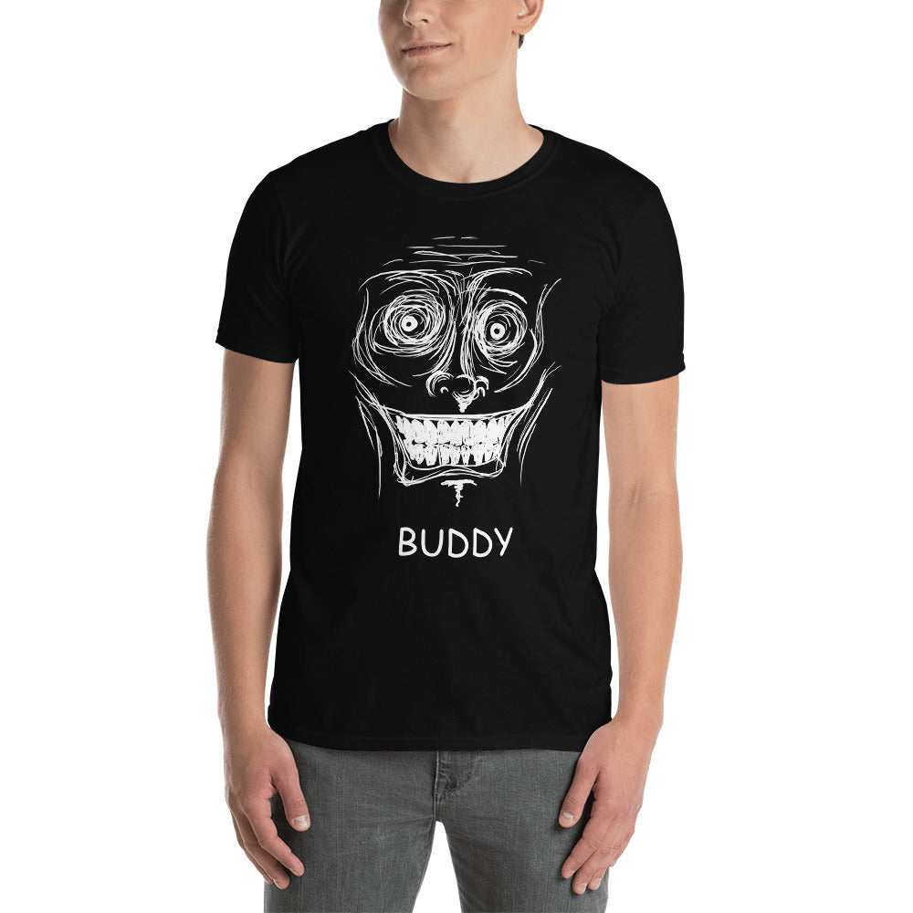 A white male stands in shot with a black t-shirt on that has a scribbled white line face with a inhumanely large grim grin on it's face. The word "BUDDY" is written in white underneath.